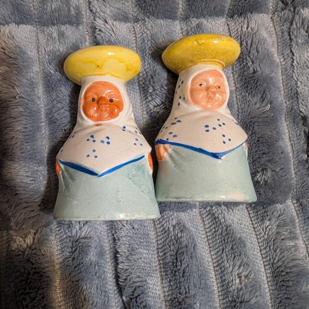 Ceramic salt and pepper shakers depicting figures in traditional dress with yell